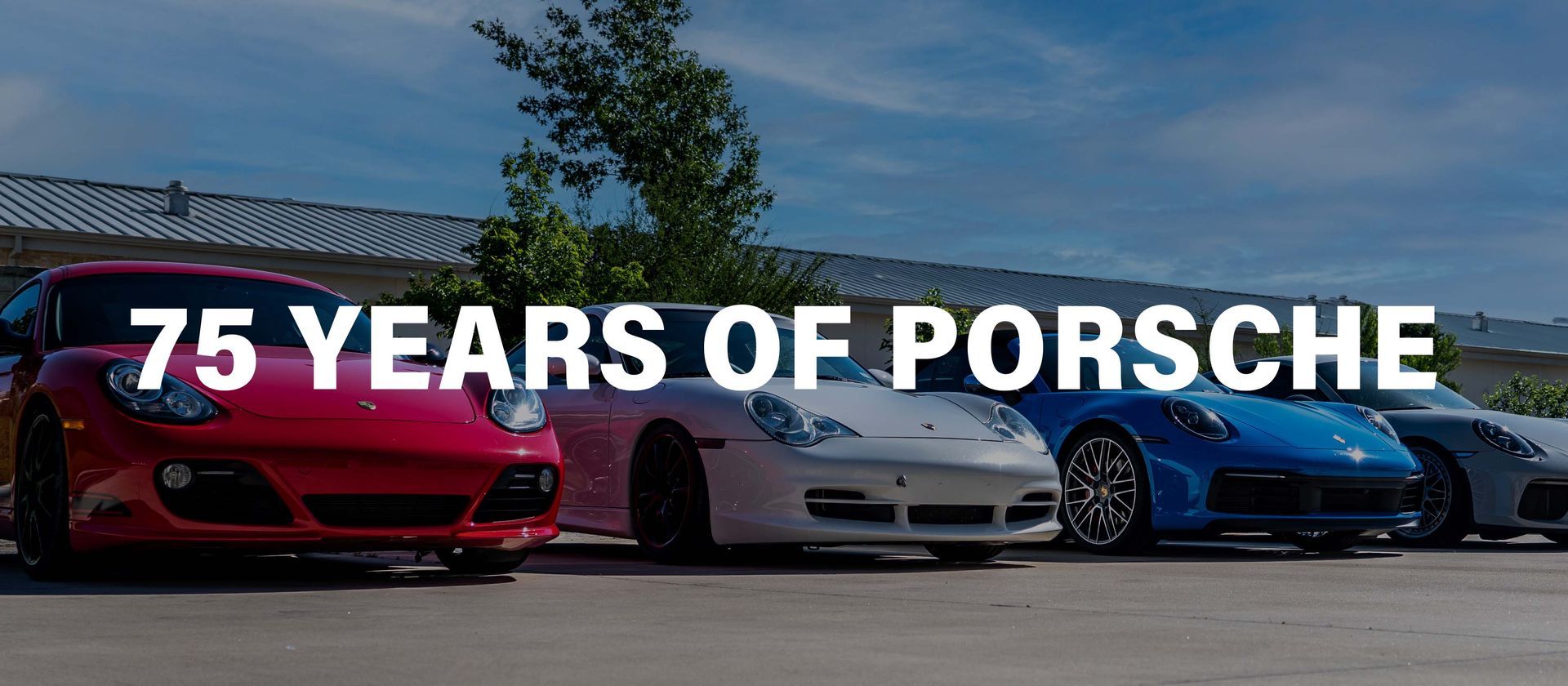 A row of porsche cars are parked in a parking lot.