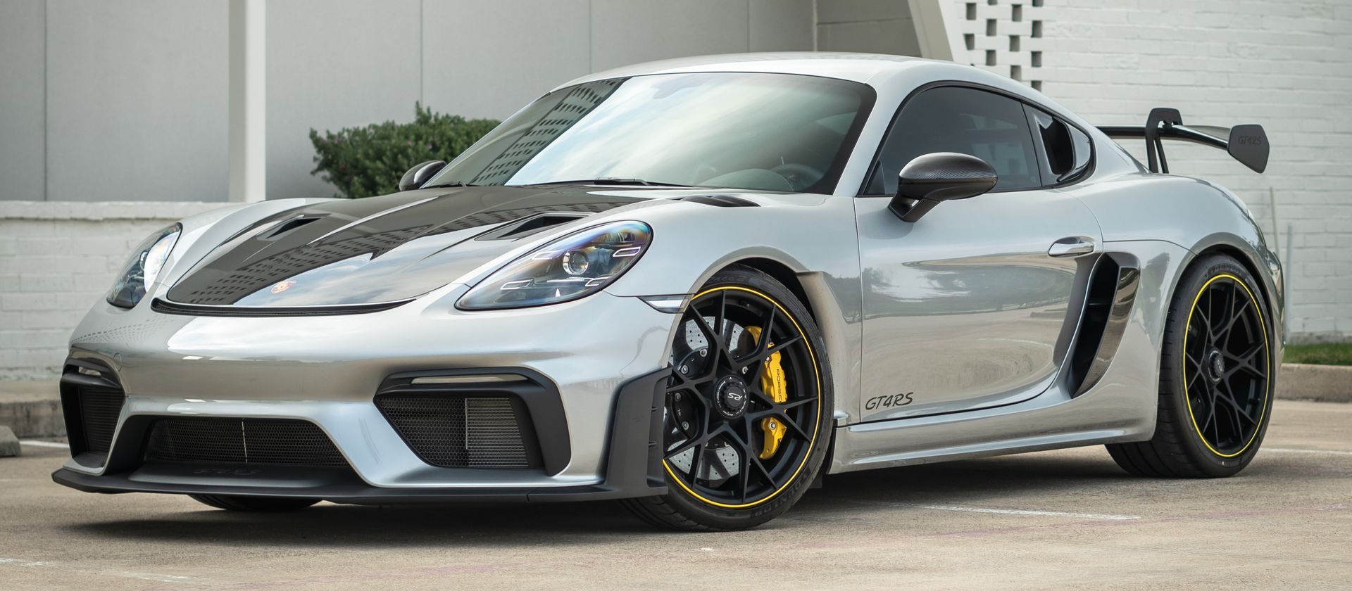 A silver porsche 911 gt4 rs is parked in a parking lot.