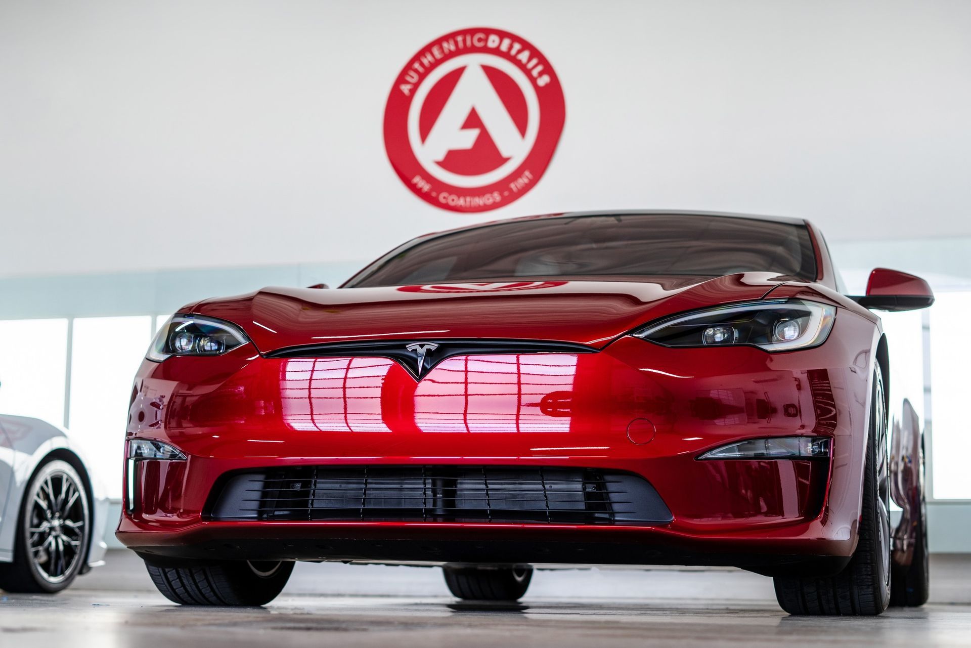 red car parked inside with Authentic Details logo