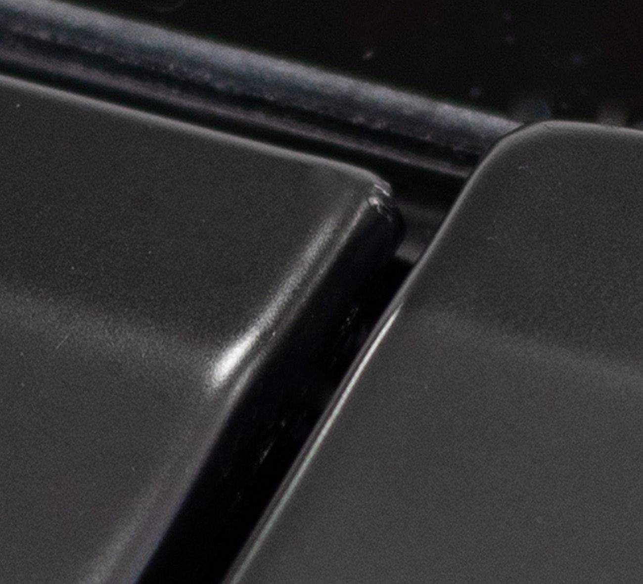 A close up of two black squares on a black surface.