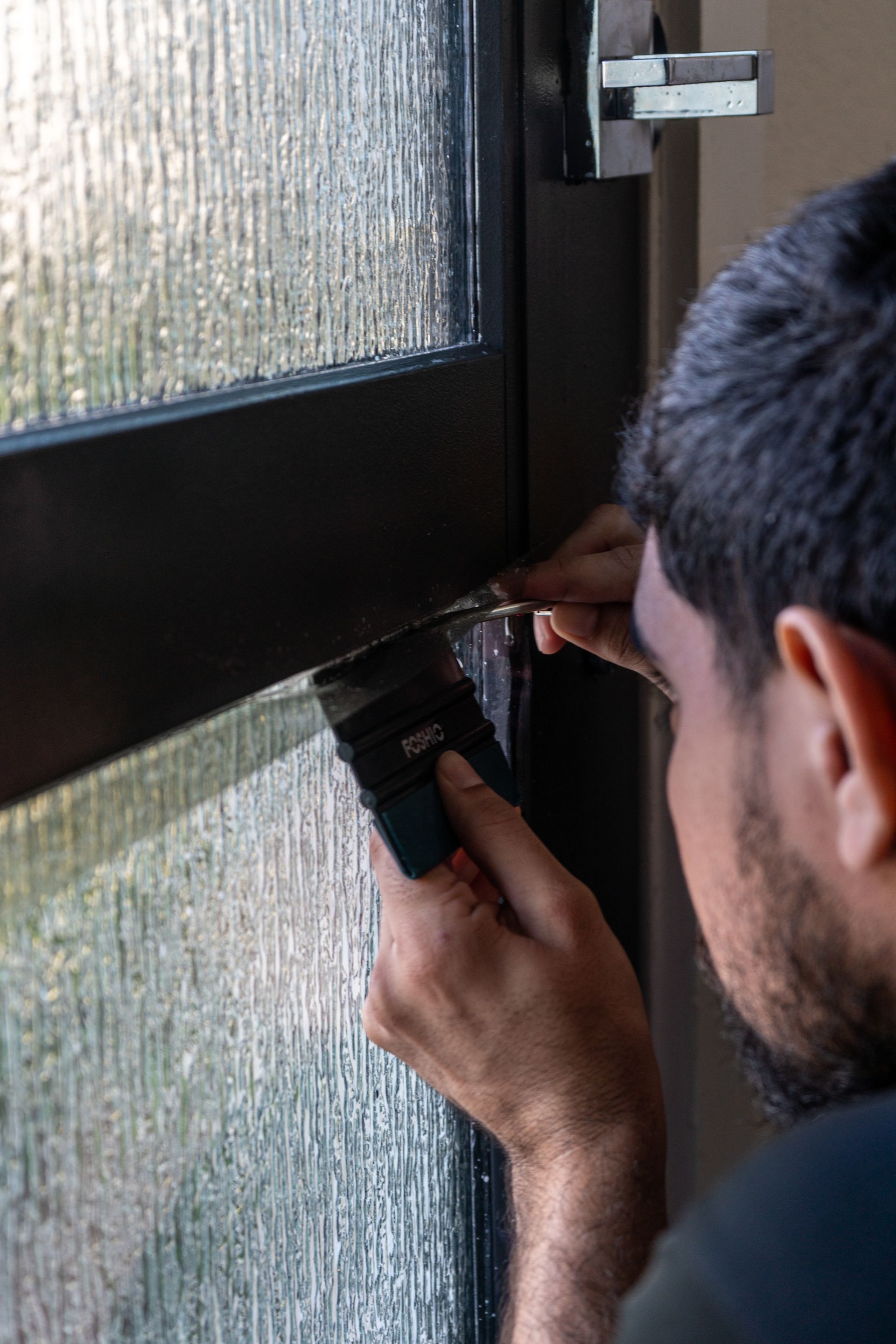 a man is using a screwdriver to fix a door lock .