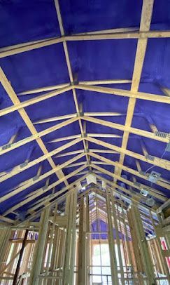 The ceiling of a building under construction with a blue tarp on it.
