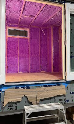 A room with purple insulation on the walls and ceiling.
