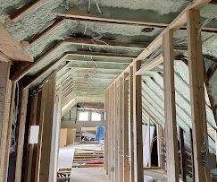 A long hallway filled with wooden beams and foam on the ceiling.
