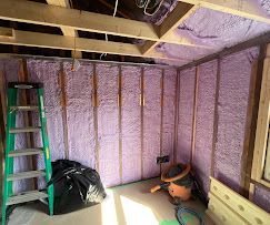 A room with a ladder and a vacuum cleaner in it.