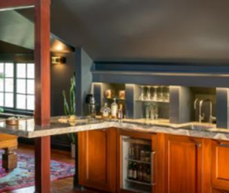 A kitchen with wooden cabinets and a marble counter top