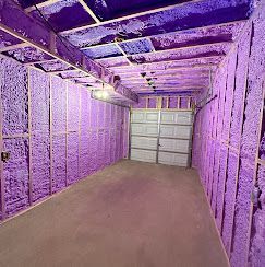A garage with purple insulation on the walls and ceiling.