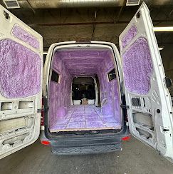 The inside of a van is covered in purple insulation.