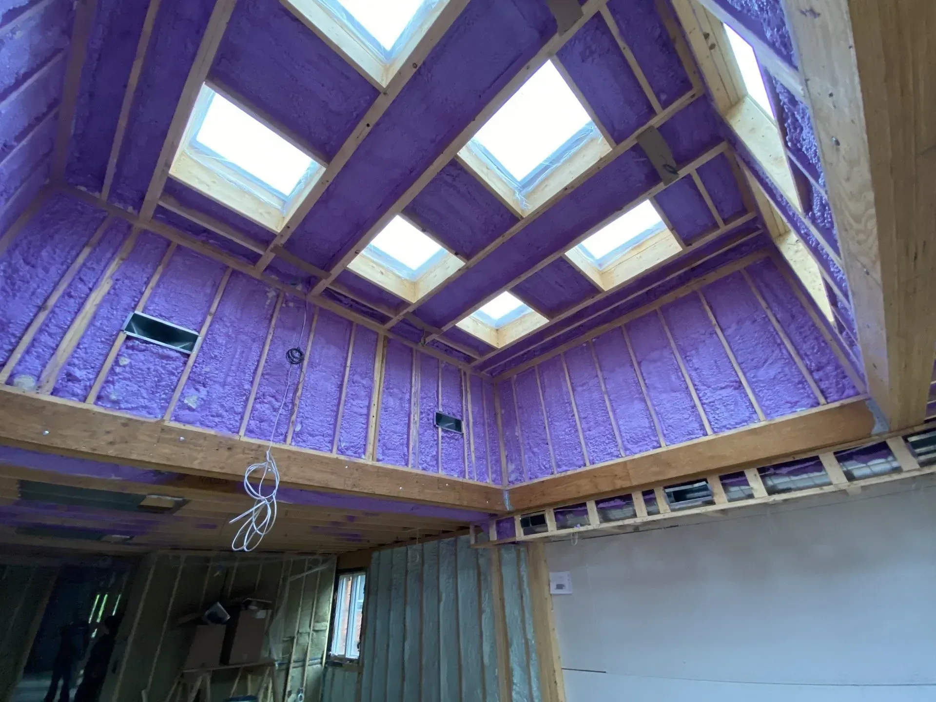 A room with purple insulation and skylights on the ceiling.