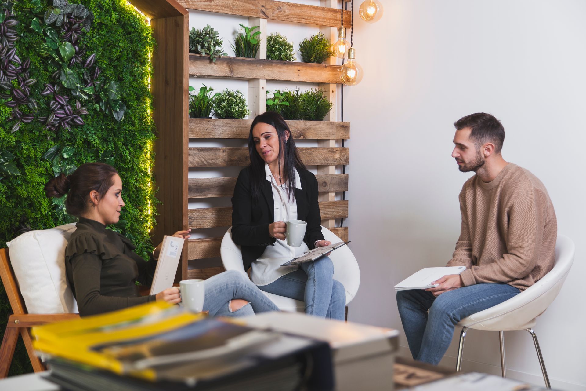 A group of people are sitting in chairs in a room having a conversation.