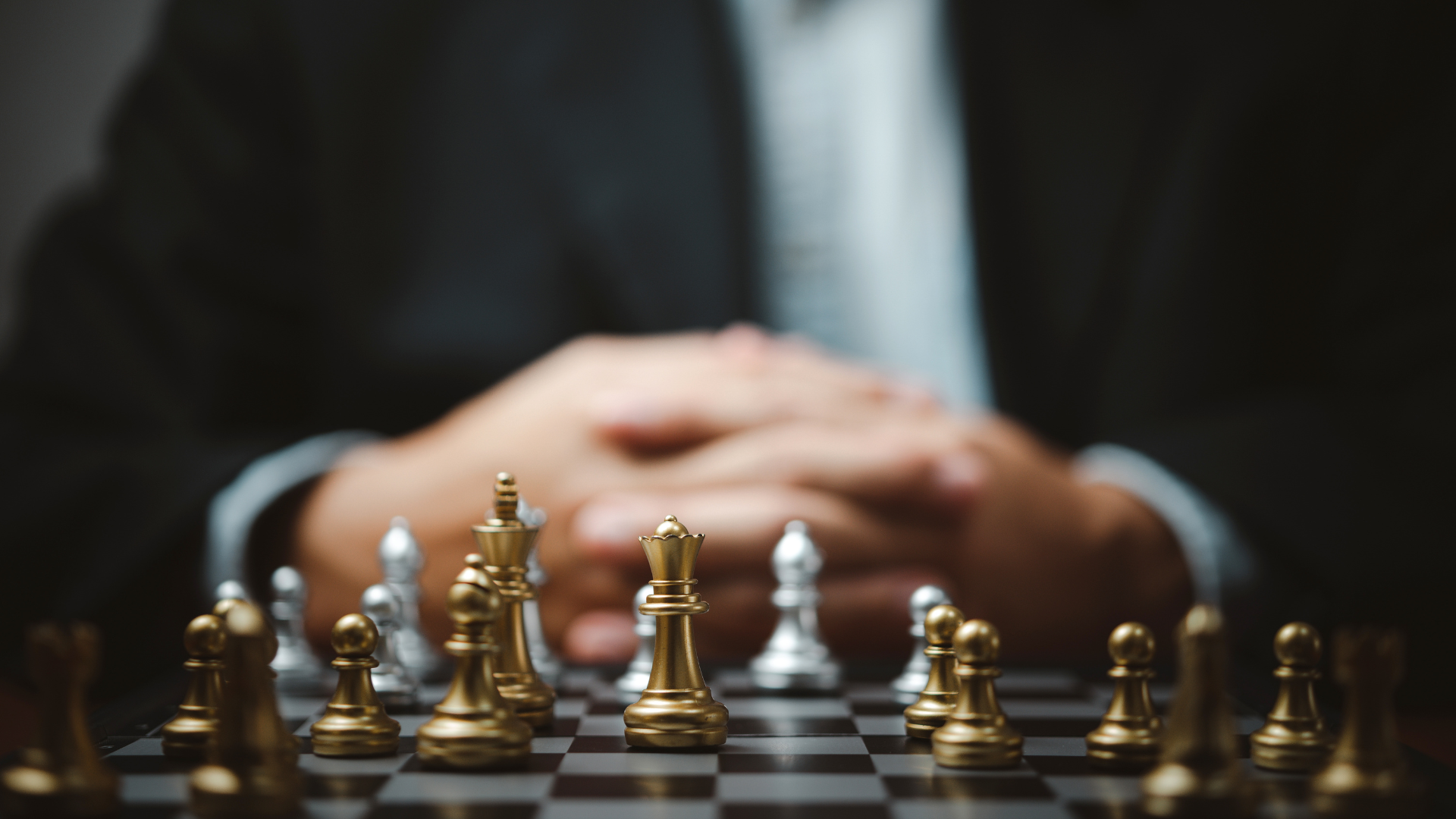 A man in a suit is playing a game of chess.