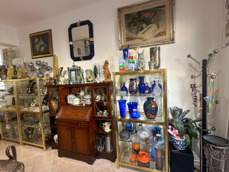 Una stanza piena di vetrine antiche, vasi e oggetti decorativi.