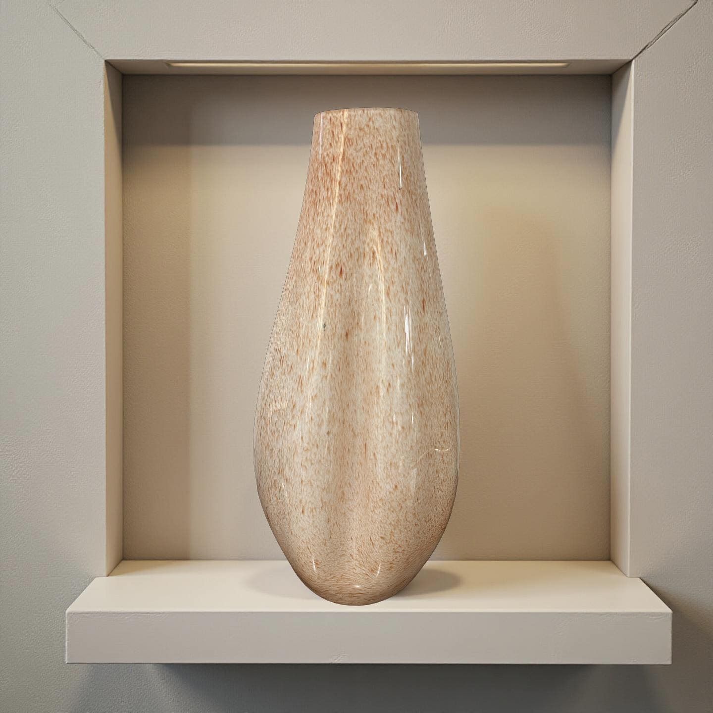 Un vaso alto e screziato esposto su una mensola bianca all'interno di una parete incassata dai toni neutri.