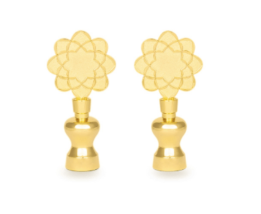 Un paio di orecchini d'oro con un disegno floreale su sfondo bianco.