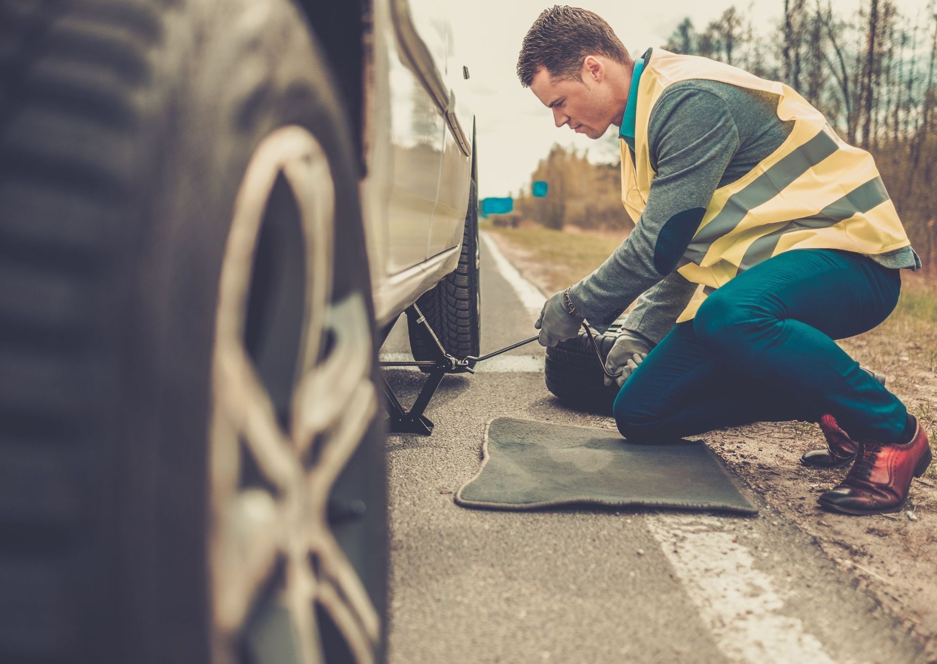 man changing wheel on roadside