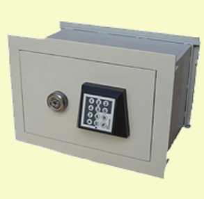 Caja fuerte de pared en color bronce con teclado y cerradura con dial.