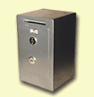 Caja fuerte de metal gris con ranura en la parte superior y dos diales.