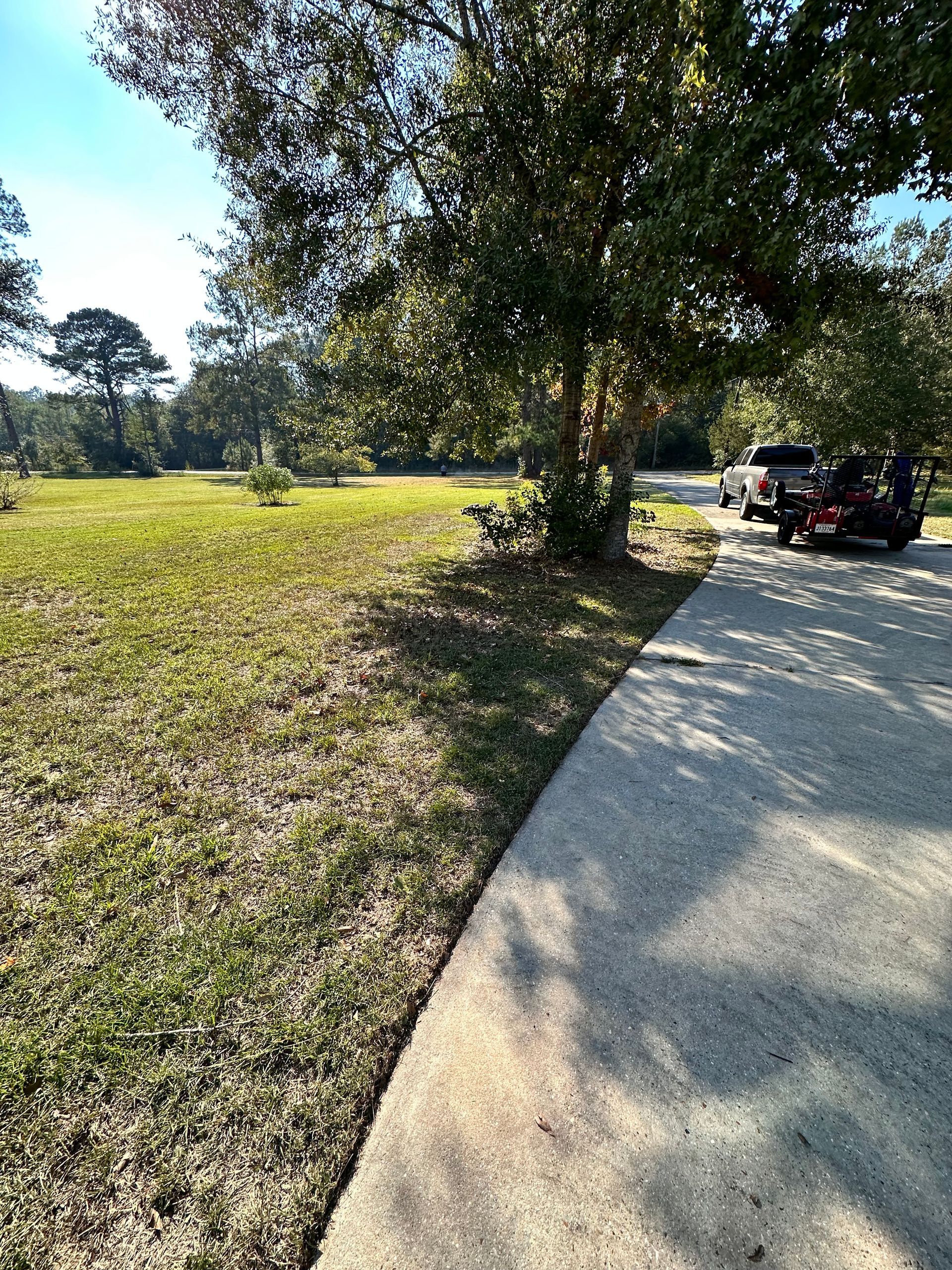 A picture of a driveway with a truck pulling lawn equipment in Mandeville, LA.