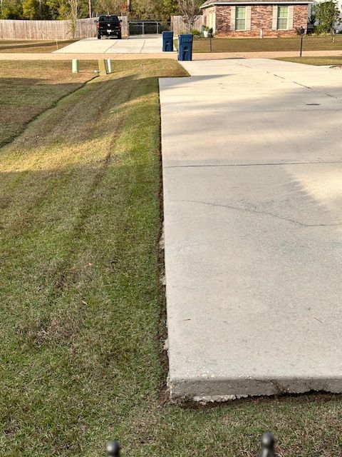 A picture of a clean yard next to a driveway in Mandeville, LA.