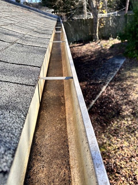 A picture of the top of a gutter on a house.