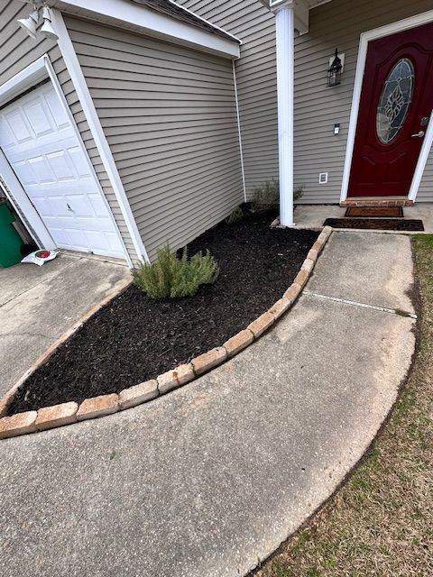 A picture of the front of a house with a small bush in front.