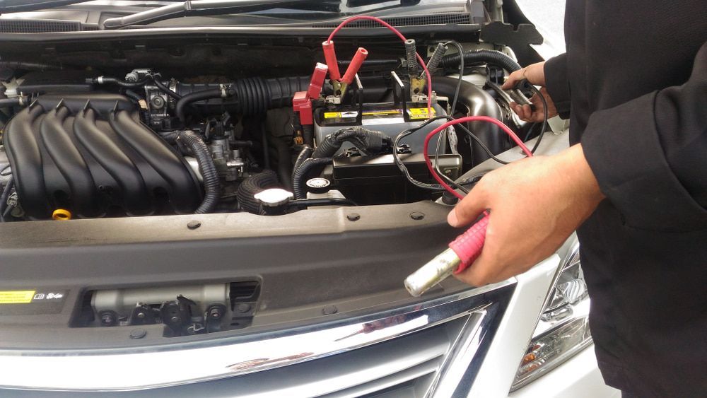 A Person Is Charging A Car Battery With A Jump Starter — Macgregor Auto In Canberra, ACT
