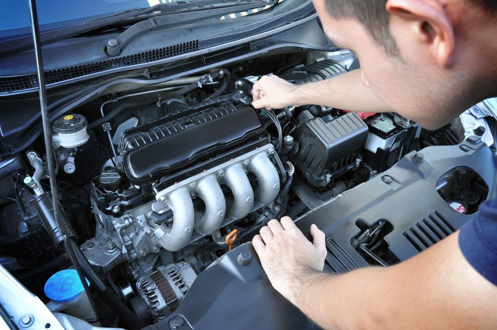 A Man Is Working On The Engine Of A Car — Macgregor Auto In Belconnen, ACT