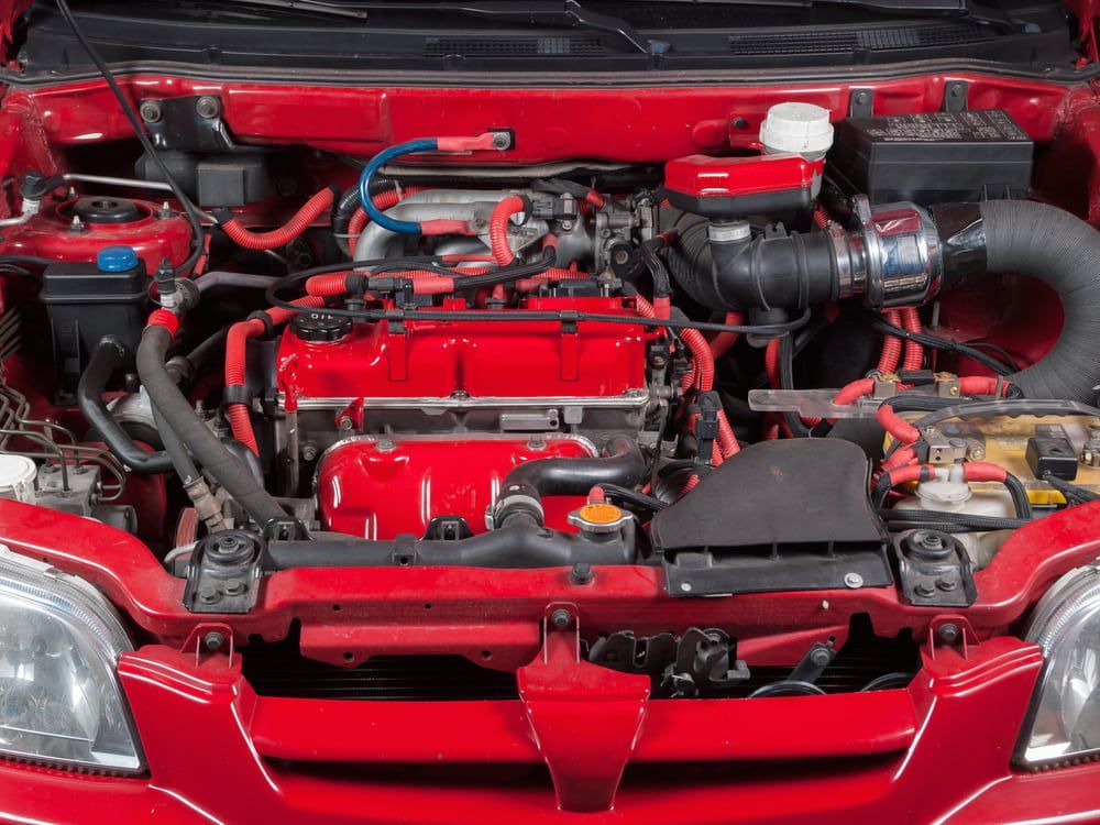 The Engine Of A Red Car Is Shown With The Hood Open — Macgregor Auto In Canberra, ACT