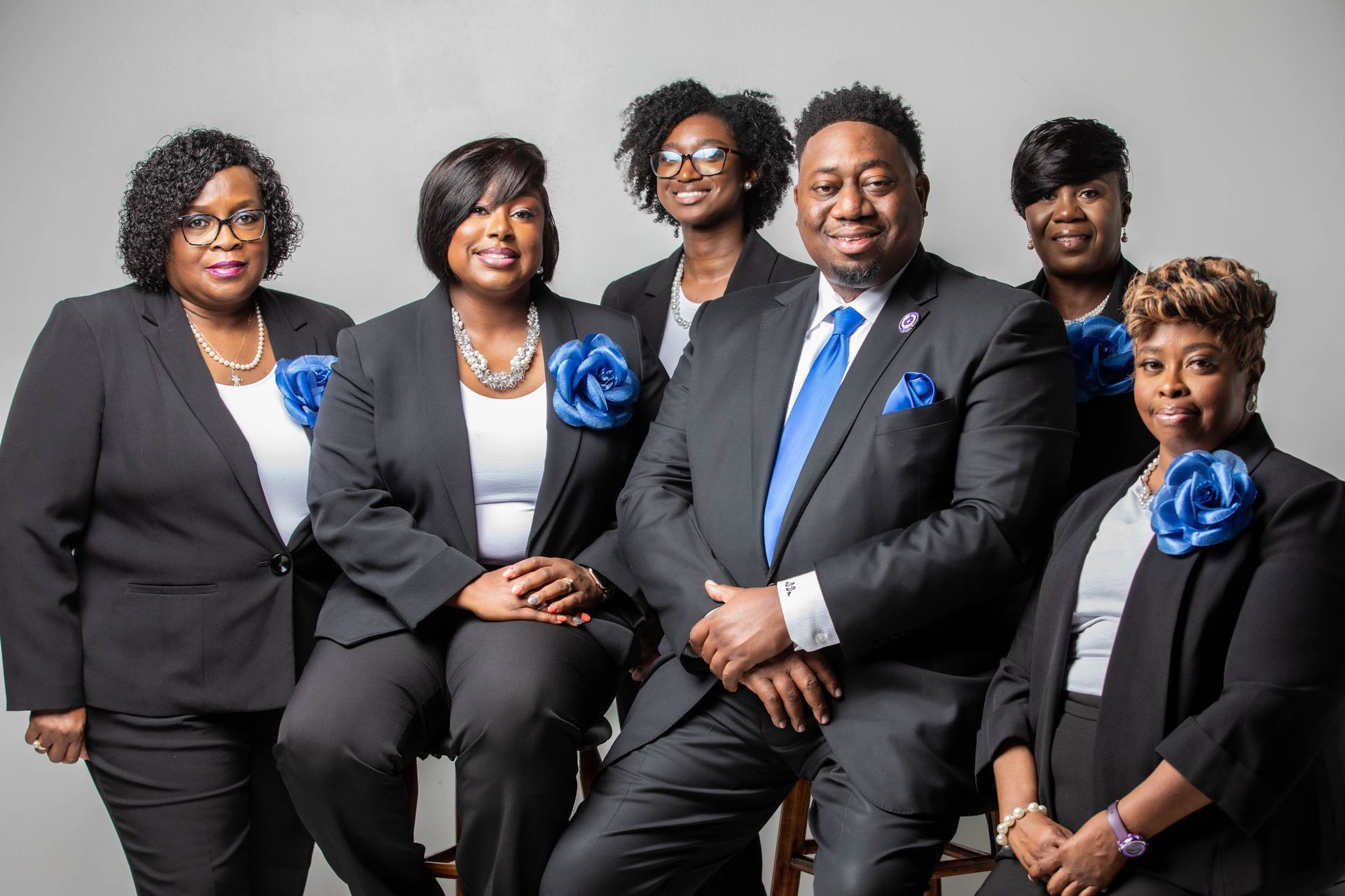 Group of people in business attire posing together, featuring blue accents.