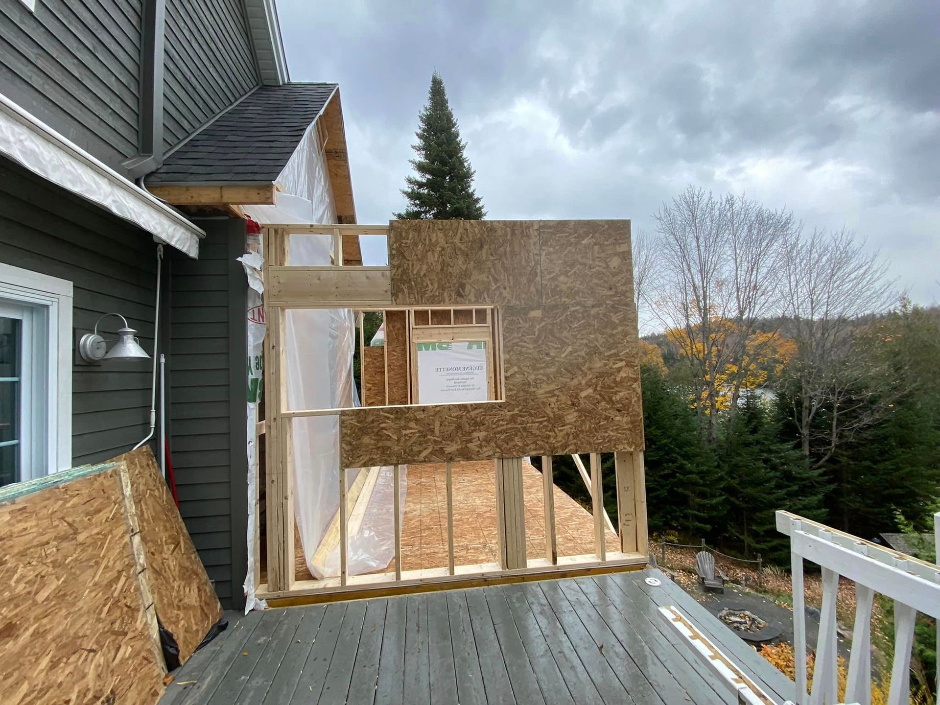 Une maison est en construction avec une terrasse en bois devant elle.