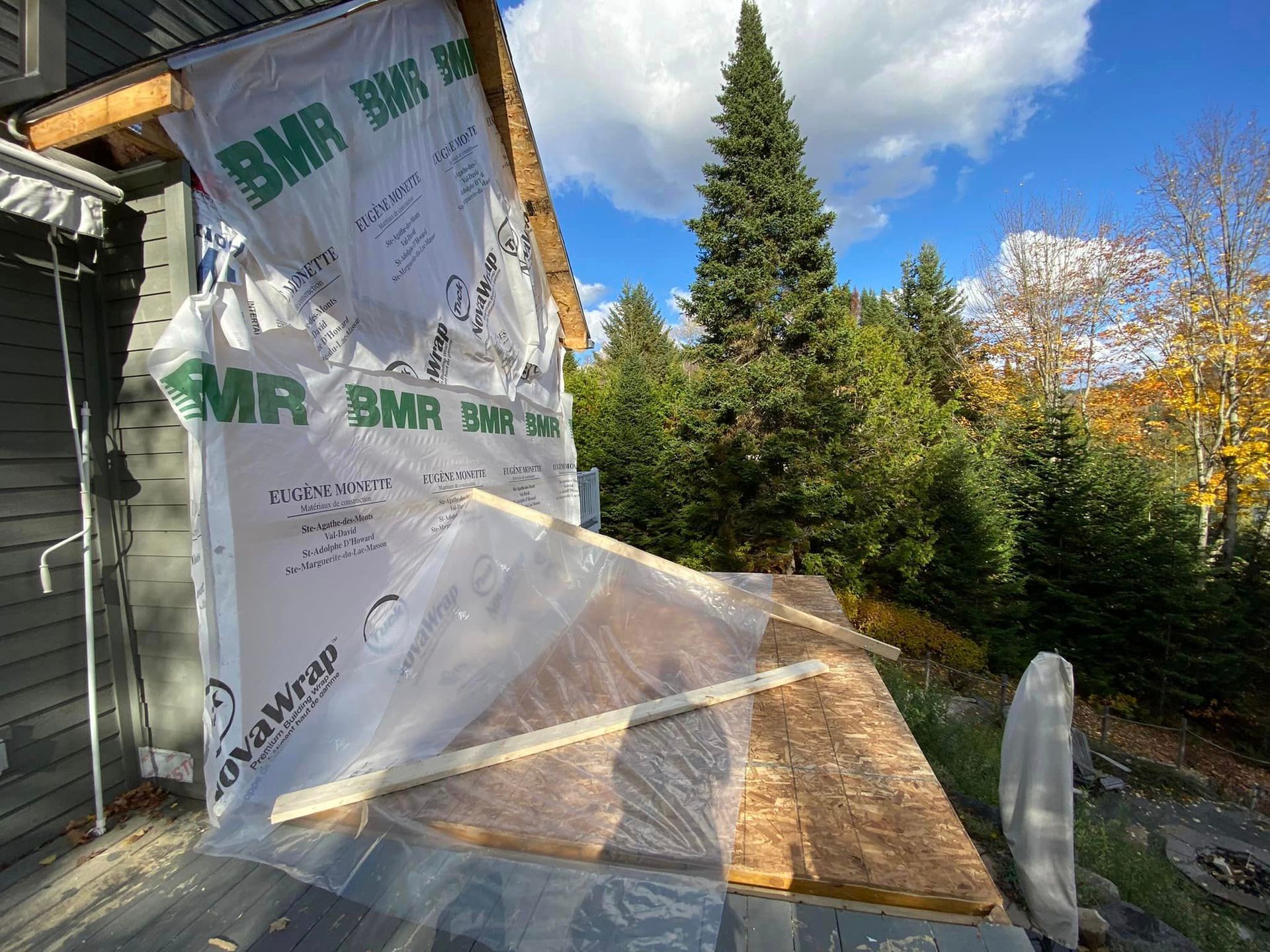 Un grand morceau de plastique recouvre le côté d'une maison.