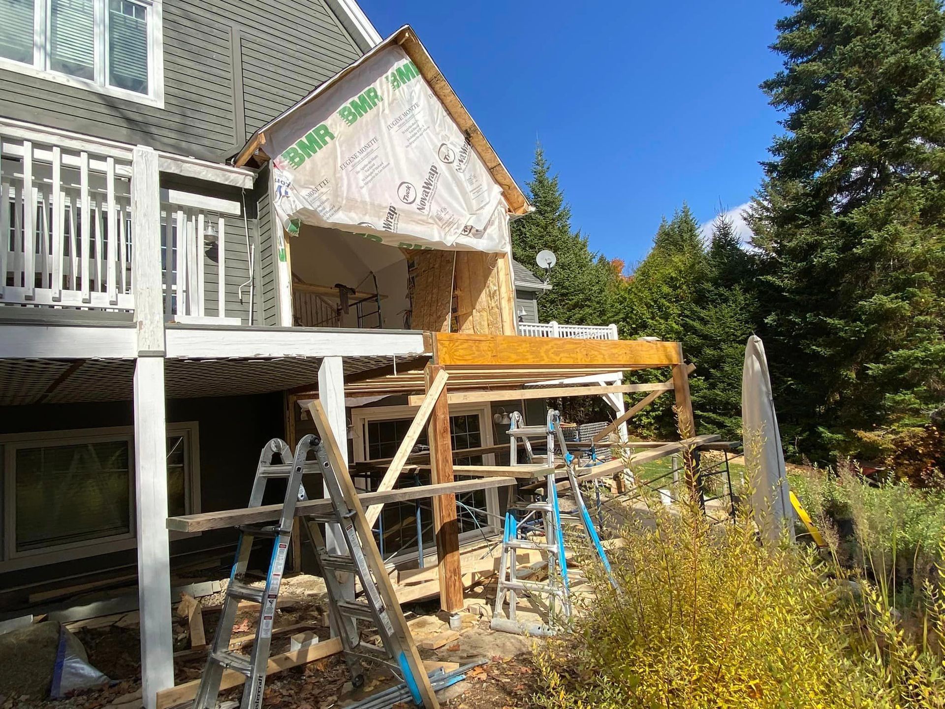 Une maison est en cours de rénovation avec une échelle devant elle.