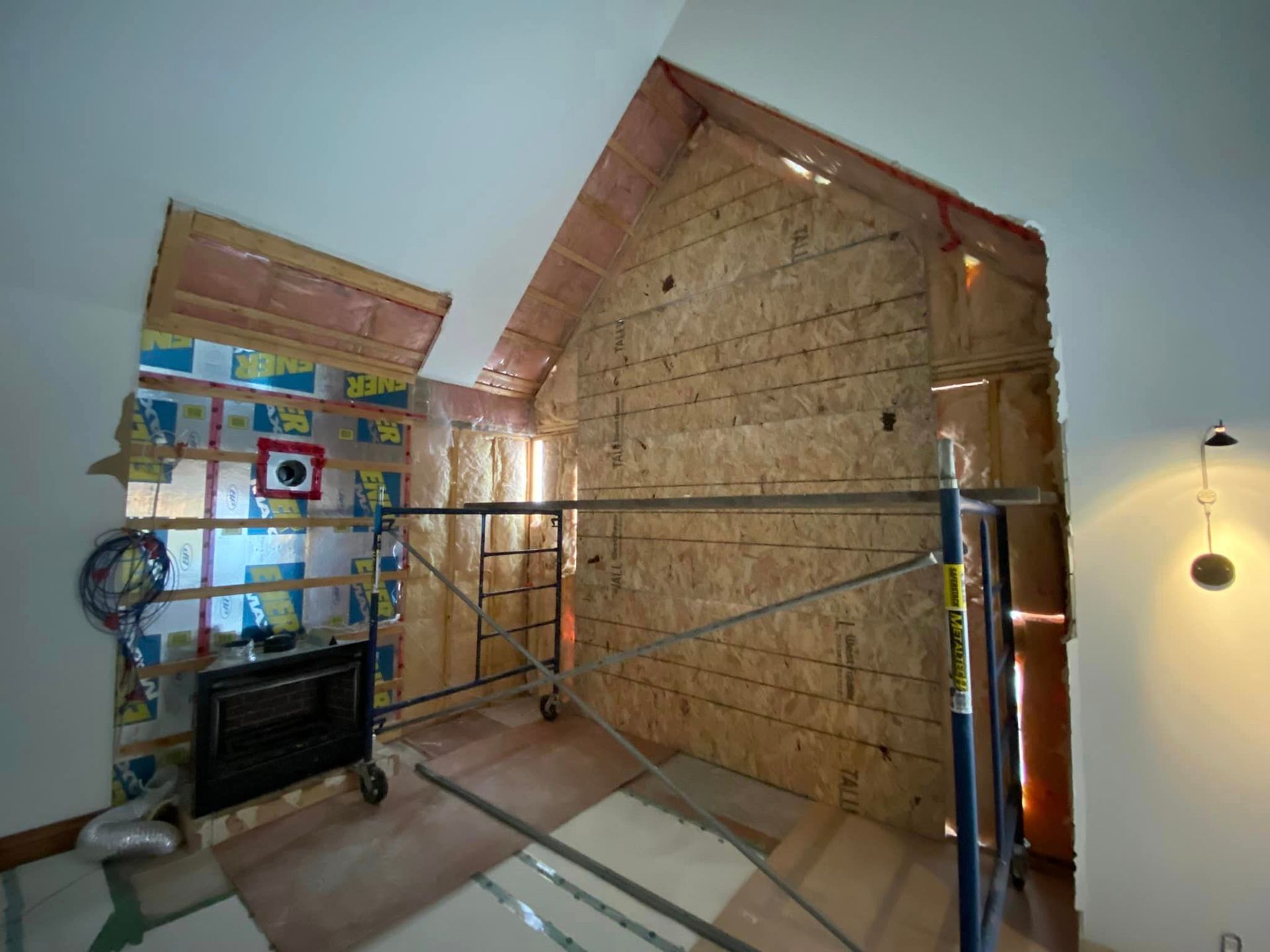 Une pièce en construction avec une cheminée et un échafaudage