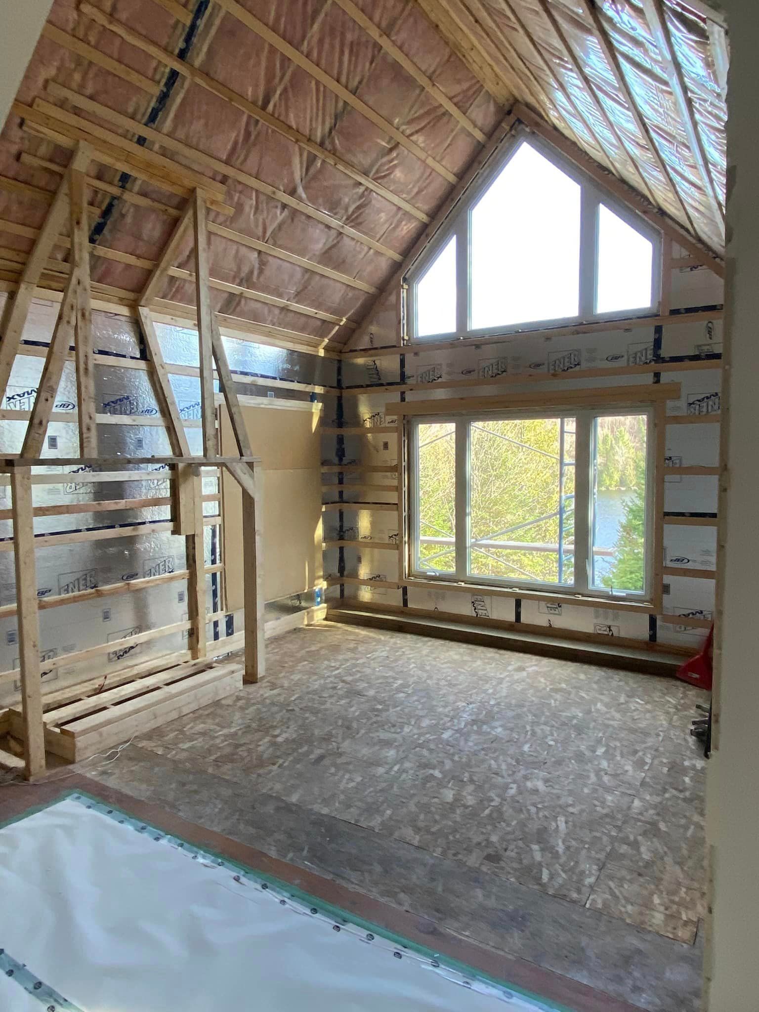 Une pièce dans une maison en construction avec beaucoup de fenêtres.