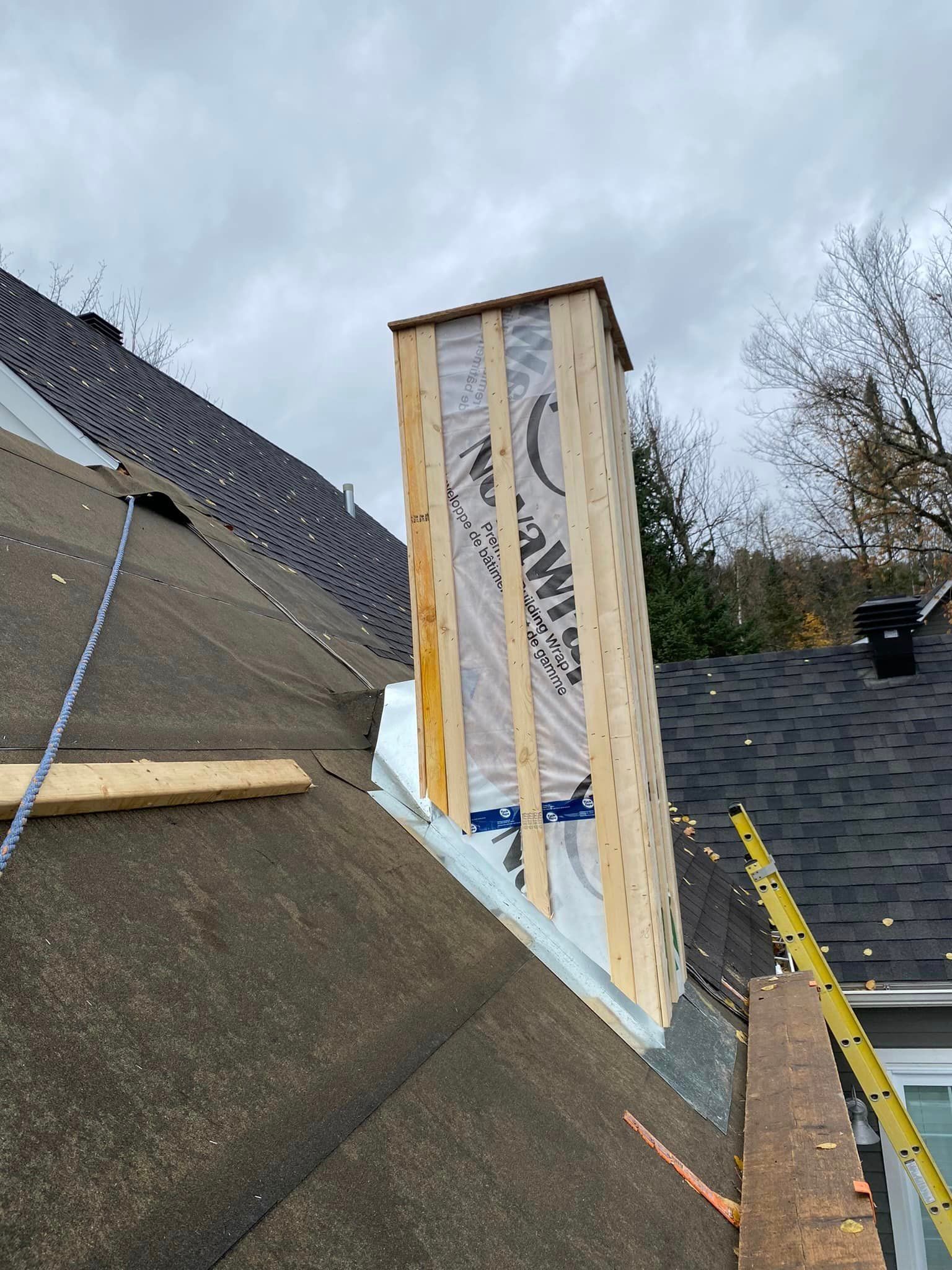 Une cheminée est en train d'être construite sur le toit d'une maison.