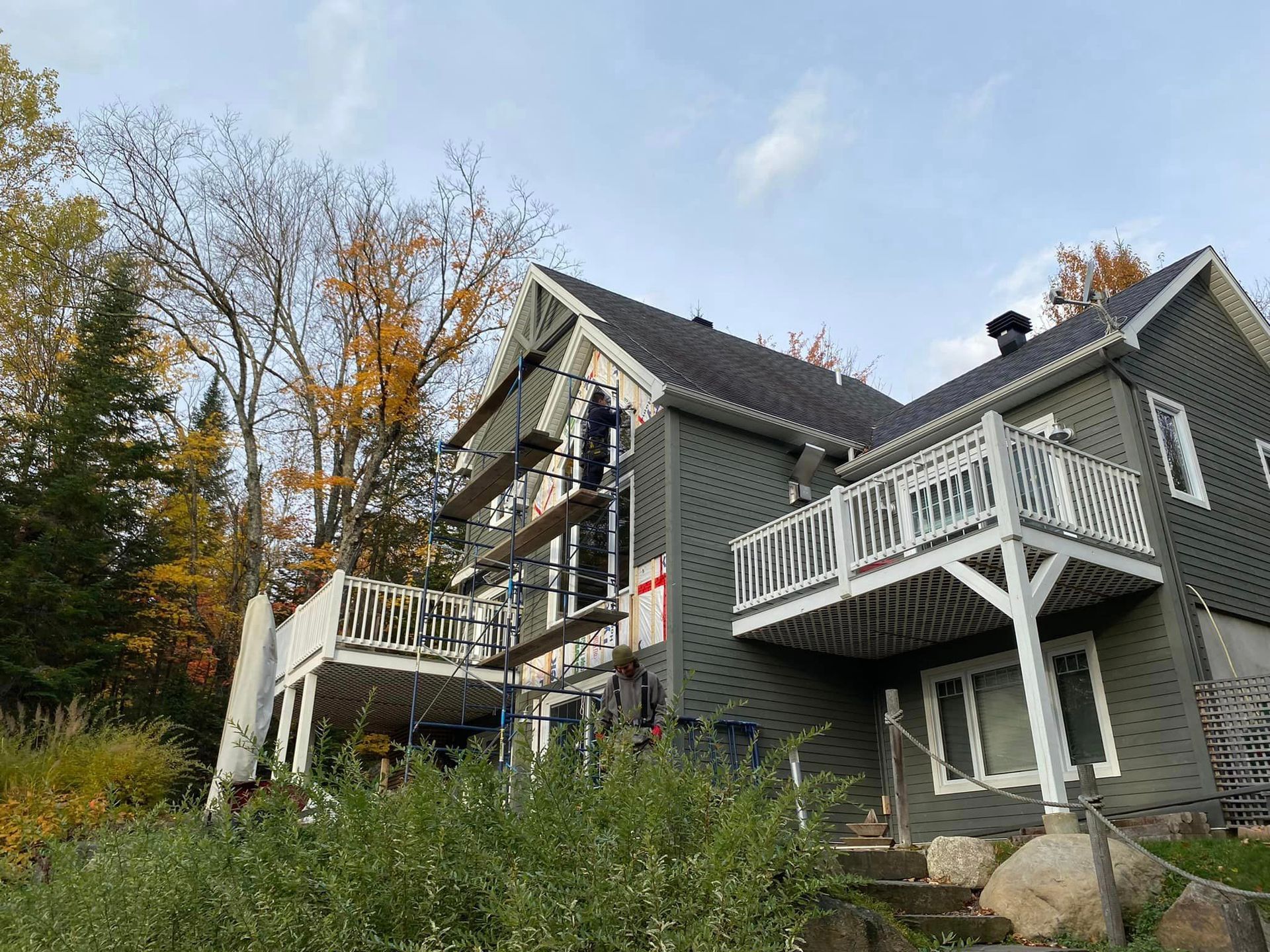 Une grande maison avec un balcon est en train d'être peinte.