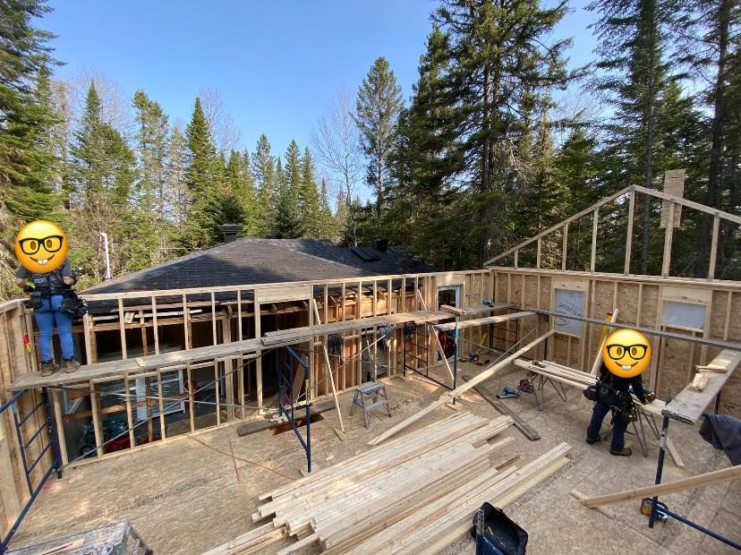 Une maison est en train d'être construite dans les bois avec beaucoup de bois.