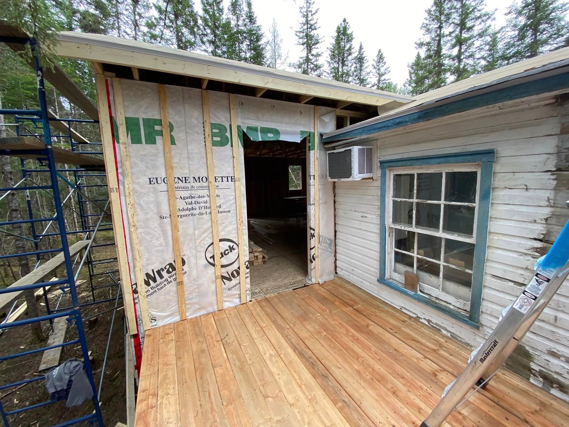 Une terrasse en bois est en cours de construction sur le côté d'une maison.