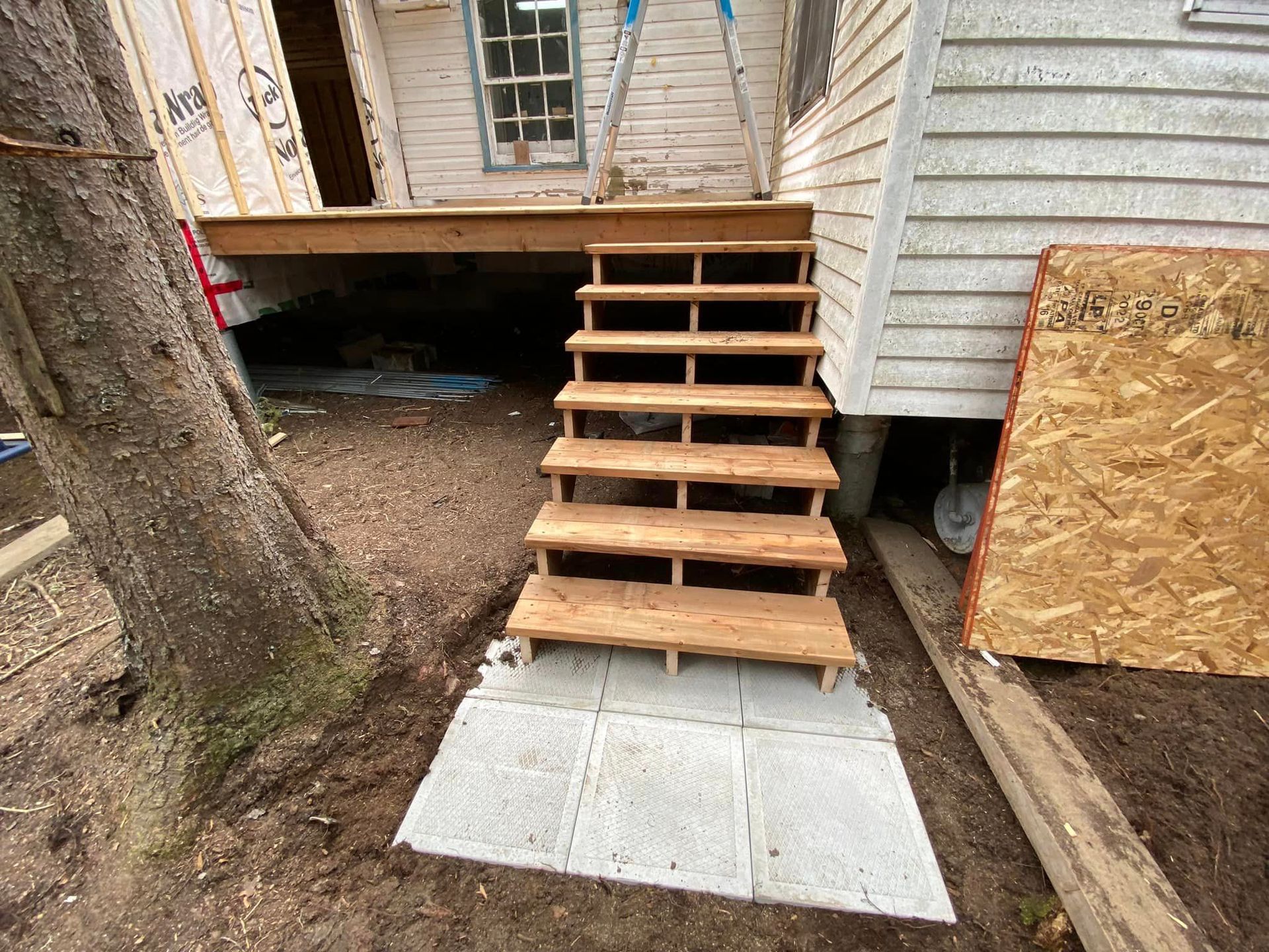 Un ensemble d'escaliers en bois menant à une maison en construction.