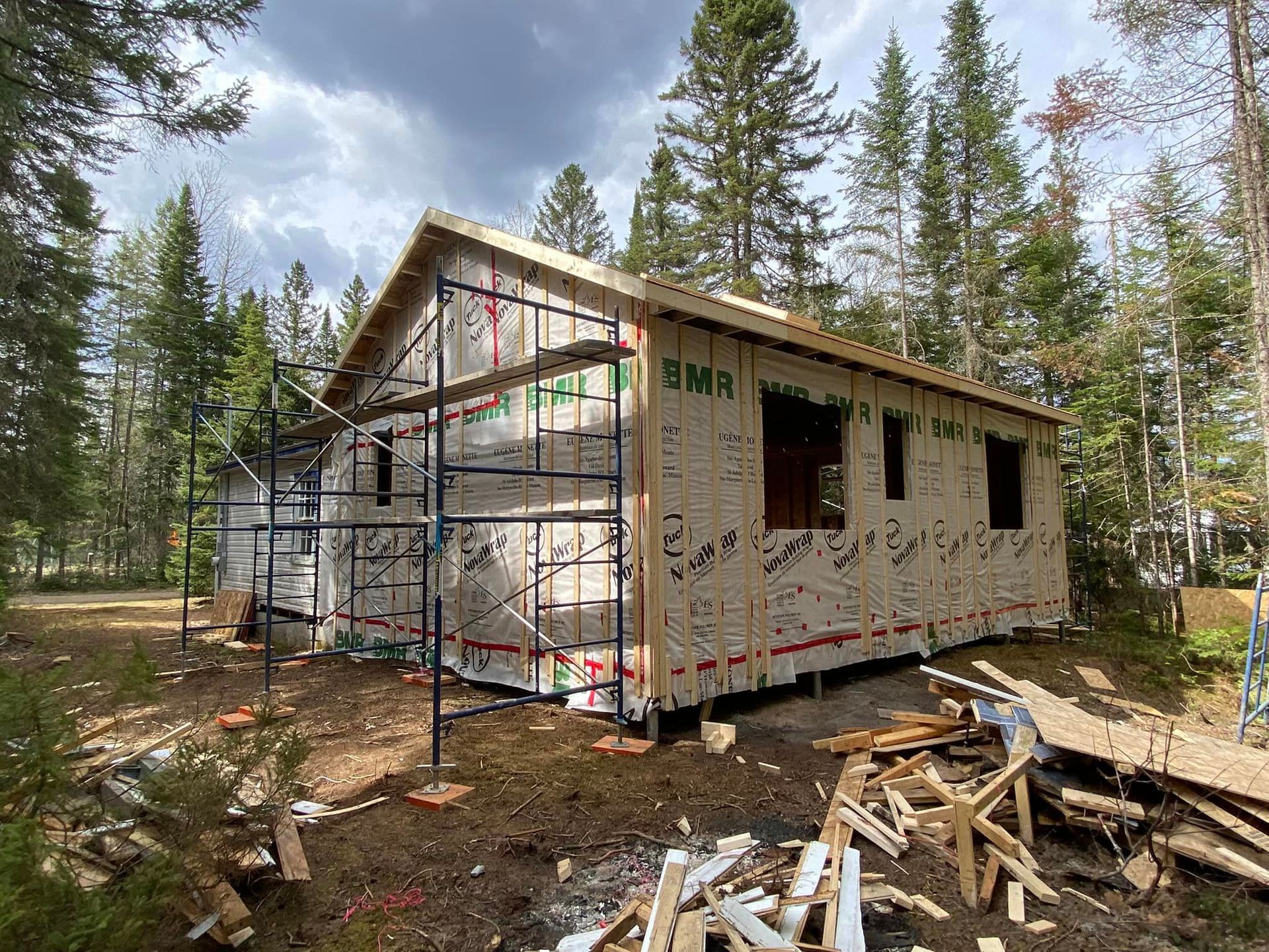 Une petite maison est en construction au milieu d'une forêt.