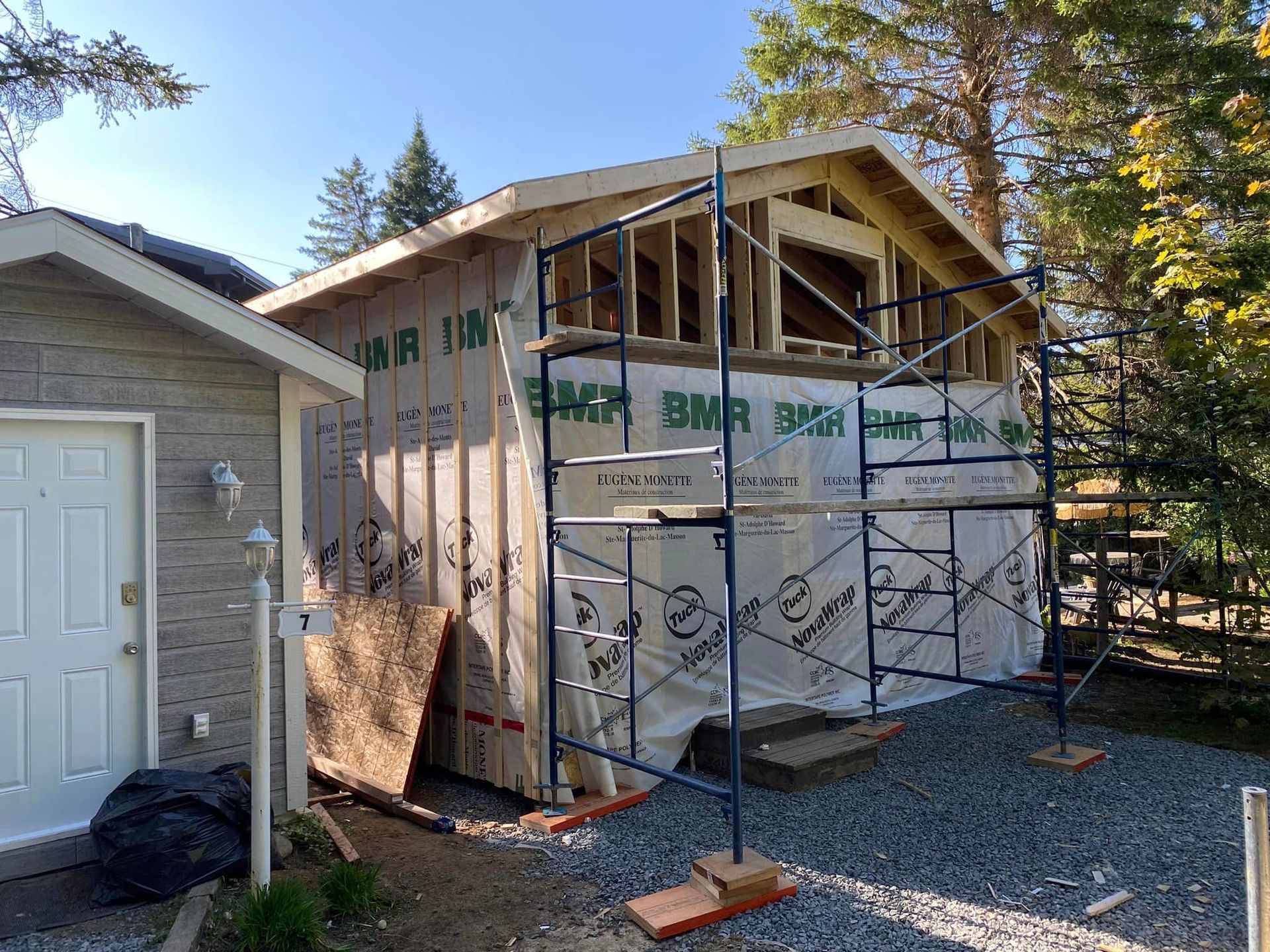 Une maison est en construction avec des échafaudages autour.