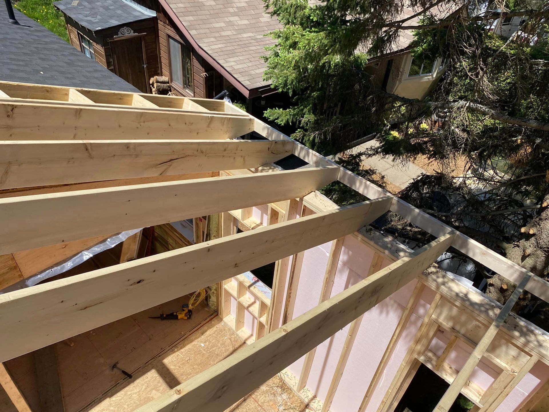 Une maison est en train d'être construite avec des poutres en bois et un toit.