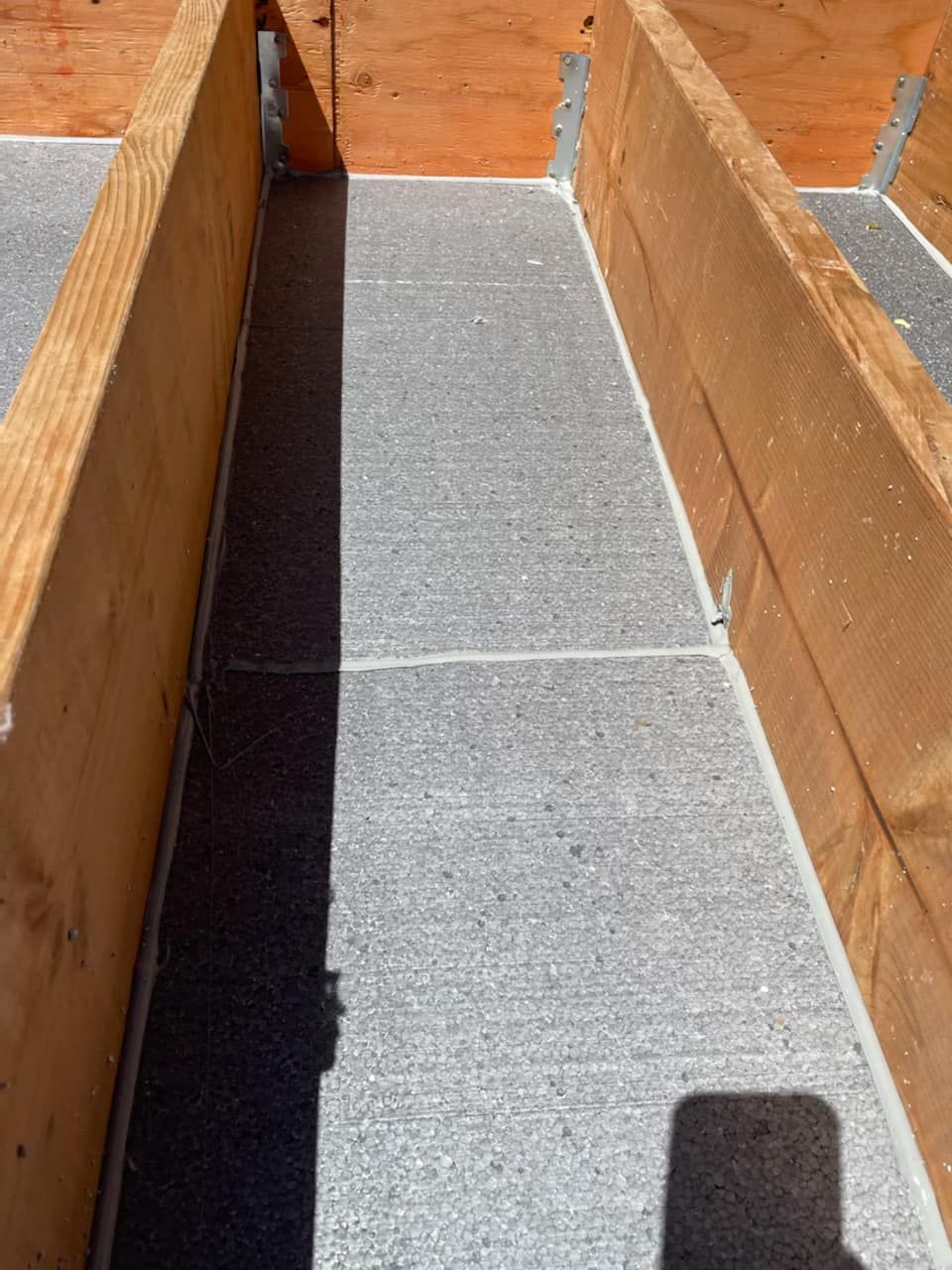 Une boîte en bois est posée sur un sol en béton.