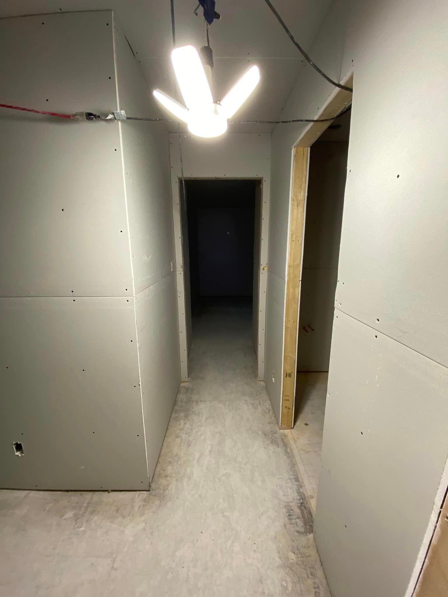 Un long couloir avec une lumière suspendue au plafond.