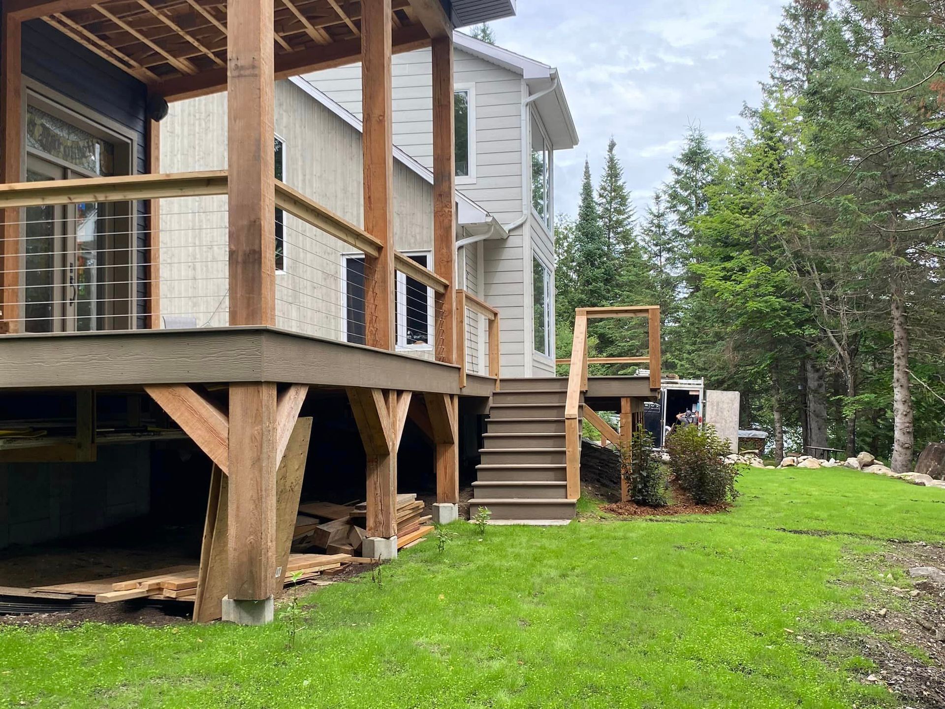 Une maison avec une grande terrasse et des escaliers dans l'arrière-cour.