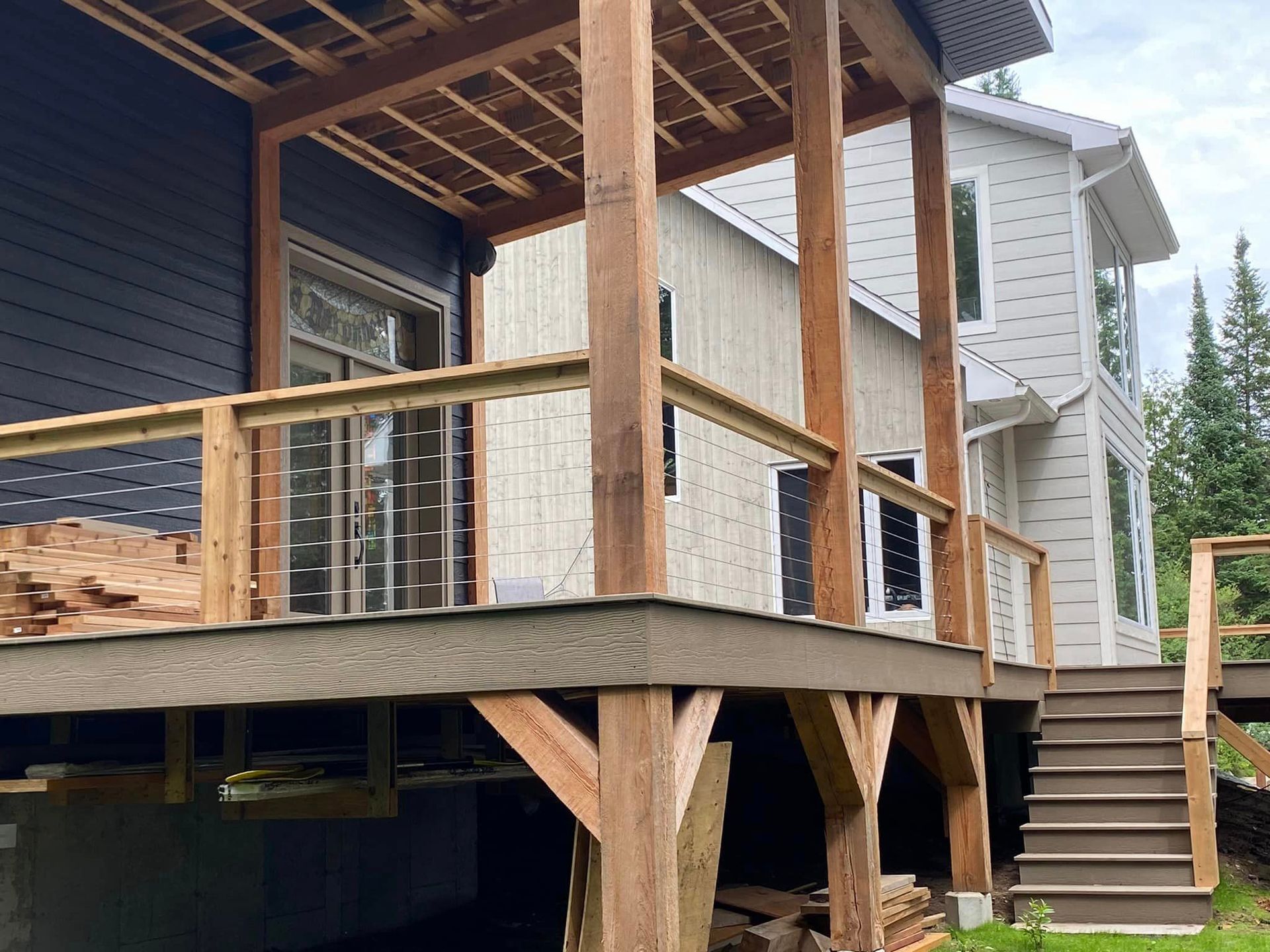 Une maison avec une terrasse en bois et des escaliers devant.