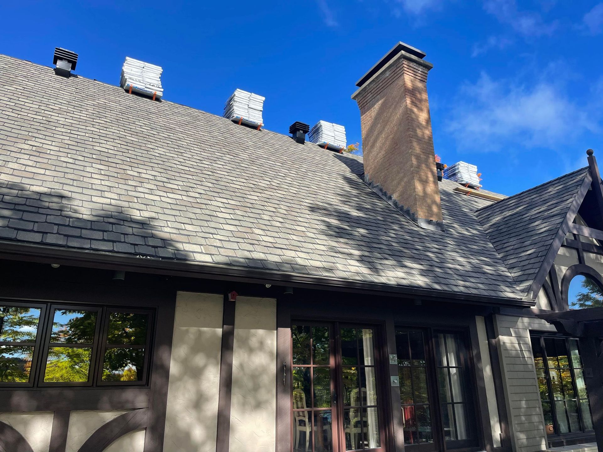 Le toit d'une maison avec une cheminée au-dessus.