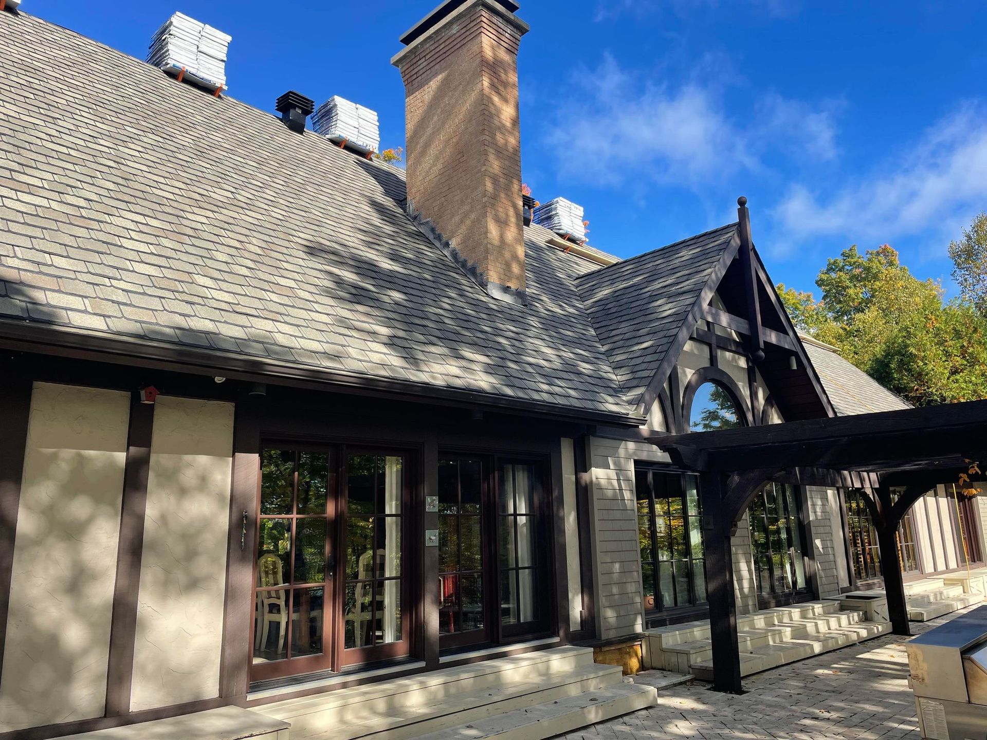 Une grande maison avec beaucoup de fenêtres et une cheminée sur le toit.