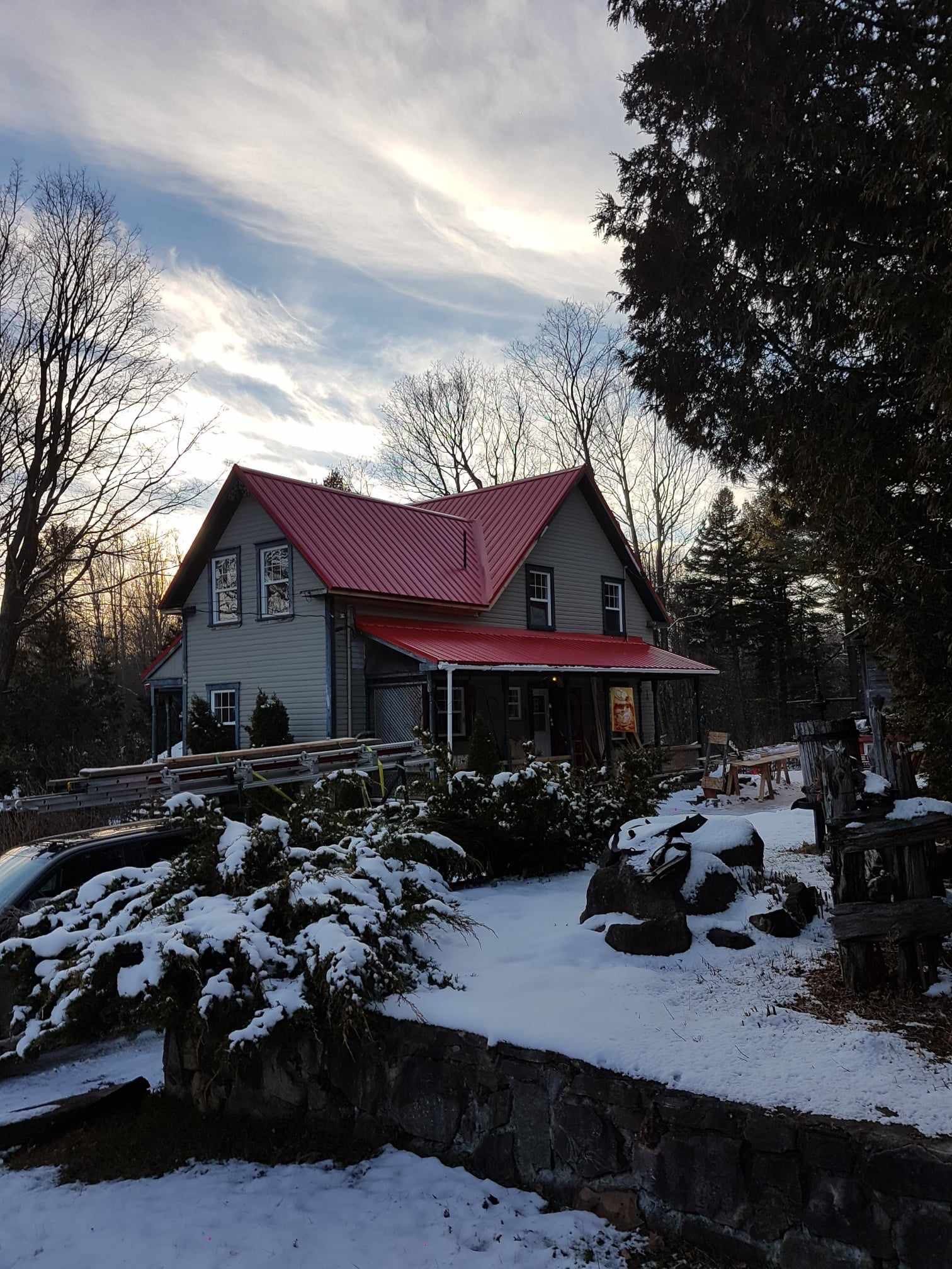 Une maison avec un toit rouge est entourée de neige