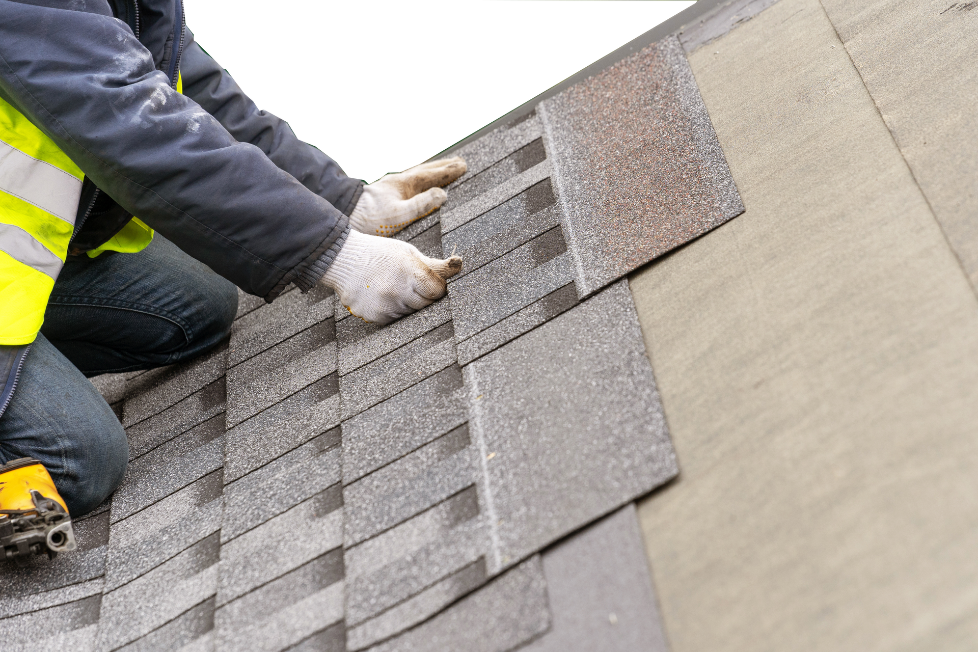 Un homme installe des bardeaux sur un toit.